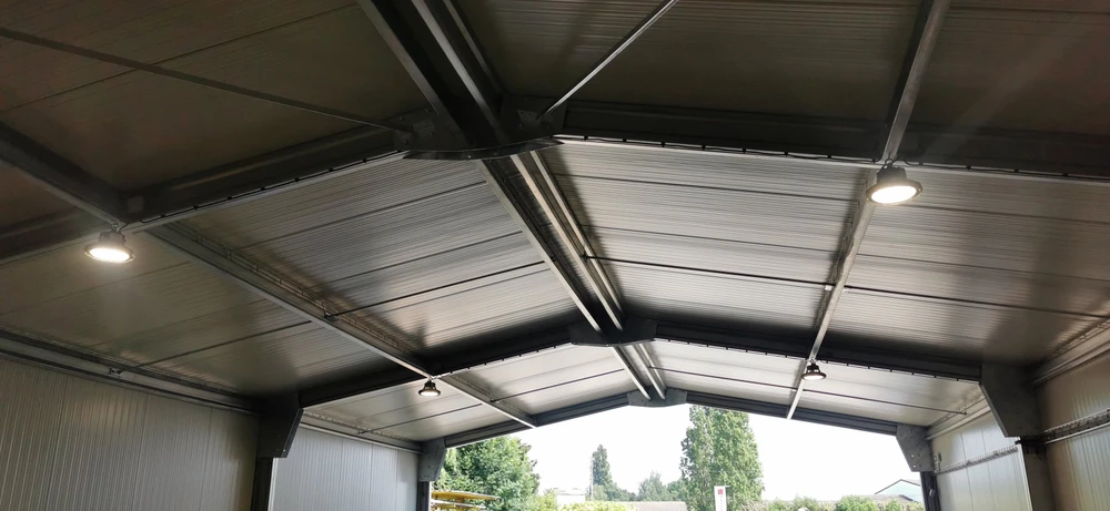 Intérieur résidentiel, main d'électricien tenant fil électrique bleu sortant d'une ouverture dans cloison placo
