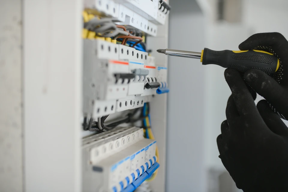 Intérieur d'un tableau électrique professionnel avec rangées de disjoncteurs modulaires installés sur rail DIN